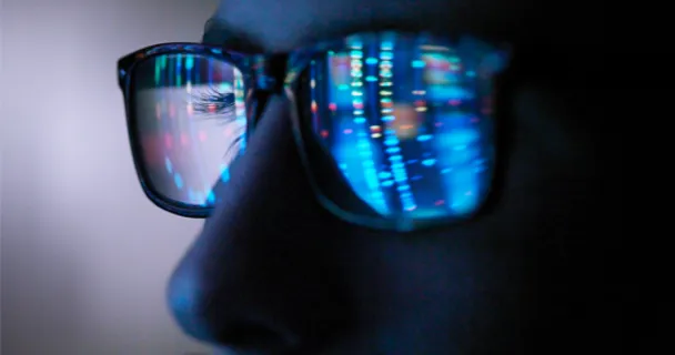Tech screen reflected in glasses