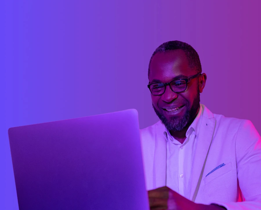 Man on laptop on purple background