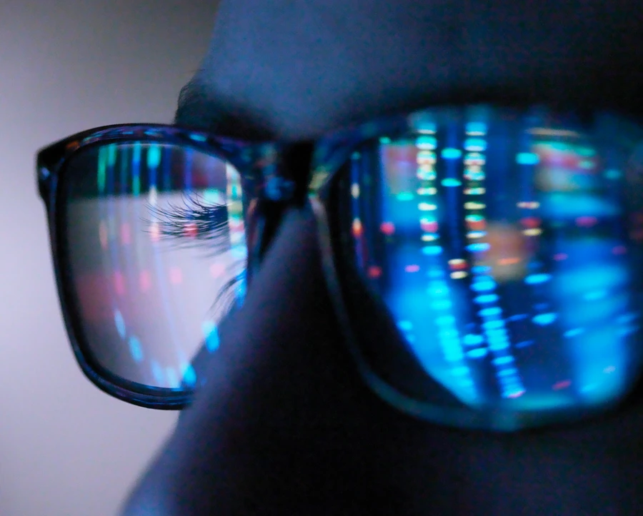 Man wearing glasses reflecting code