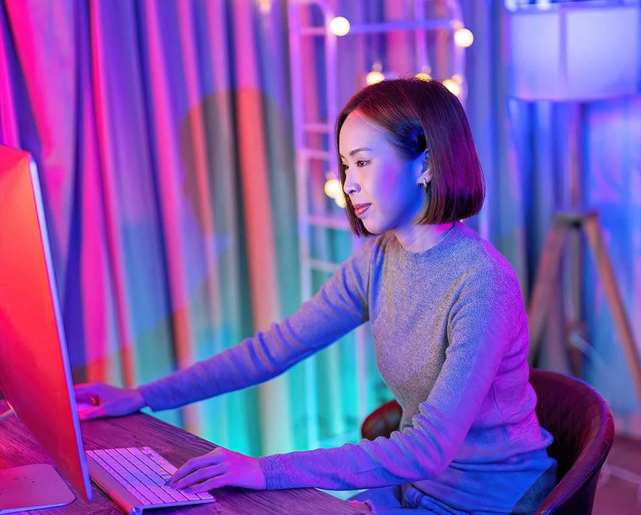 Woman on laptop with a purple background