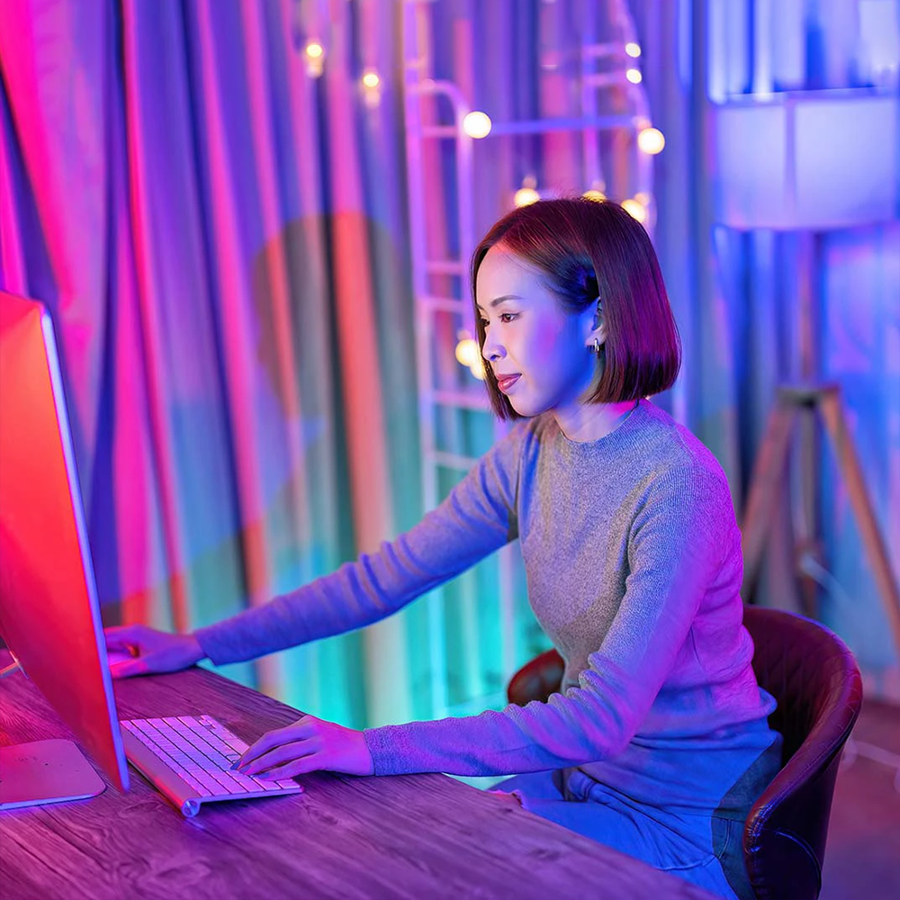 Woman on laptop with a purple background